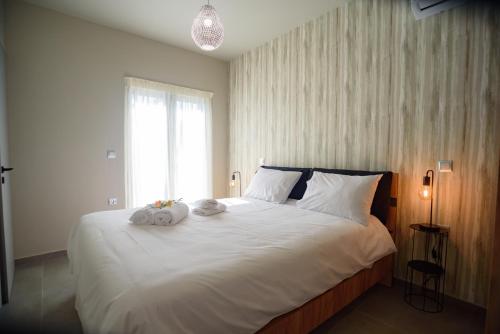 a bedroom with a large bed with two towels on it at Petousis Villas in Galatás
