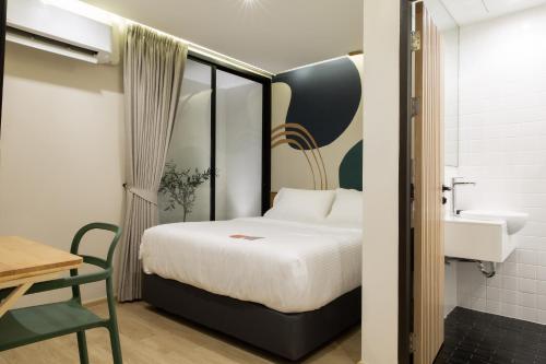 a bedroom with a bed and a sink and a desk at Double B Hostel in Bangkok