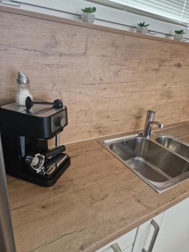 a coffee machine sitting on a counter next to a sink at Family apartment Moravske Toplice in Moravske Toplice