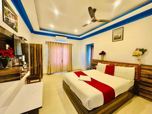 sypialnia z dużym łóżkiem z czerwoną i białą pościelą w obiekcie Sun Star International Hotel 24/7 w Bhairāhawie