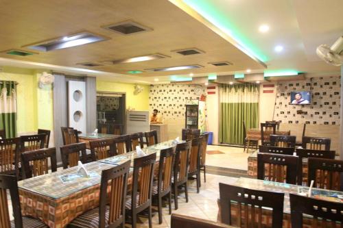un restaurant avec des tables et des chaises dans une salle dans l'établissement Hotel Raj, à Purî