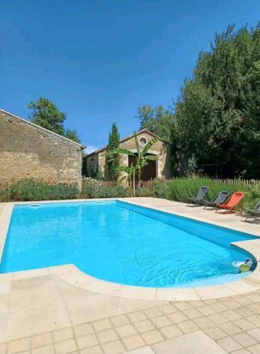 une piscine avec de l'eau bleue devant une maison dans l'établissement Château de famille en Poitou, à Coudavid