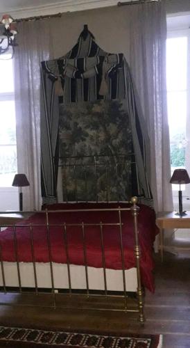 - un lit à baldaquin dans une chambre avec fenêtres dans l'établissement Château de famille en Poitou, à Coudavid