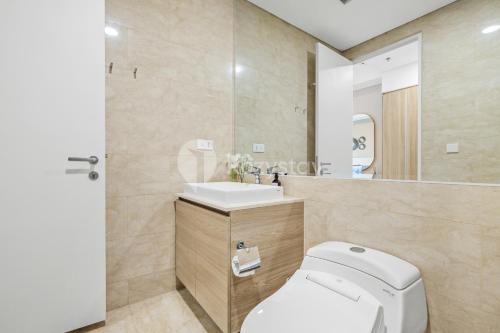 ein Badezimmer mit einem WC, einem Waschbecken und einem Spiegel in der Unterkunft Thames by Kozystay - 2BR - Near GI Mall - Thamrin in Jakarta