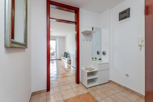 a hallway with a mirror and a white wall at Angie in Baška