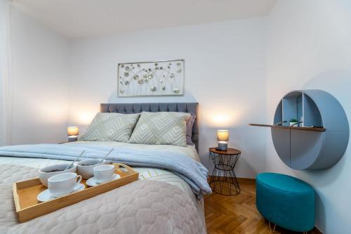 a bedroom with a bed with a tray with cups on it at Angie in Baška