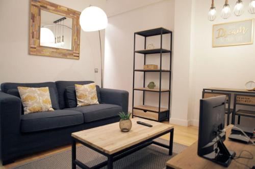 sala de estar con sofá azul y mesa en Cozy 2 bedrooms apartment in Chamberi (A.M), en Madrid