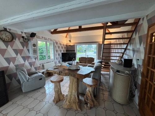 un salon avec une table et quelques chaises dans l'établissement À l'orée du bois, à Étaples
