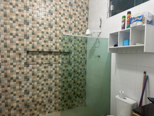 uma casa de banho com um chuveiro em azulejo e um WC. em Loft privativo . em Macapá