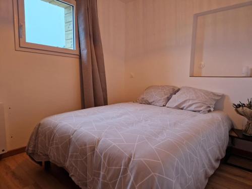 un lit dans une chambre avec une fenêtre dans l'établissement Le 4.02 appartement proche du centre, à Lannion