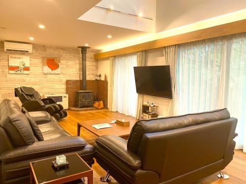 a living room with leather furniture and a flat screen tv at Rental Villa Karuizawa Honors Hill - Vacation STAY 02223v in Oiwake