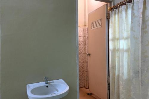 a bathroom with a sink and a shower at OYO 93876 Athirah Kost in Tolo