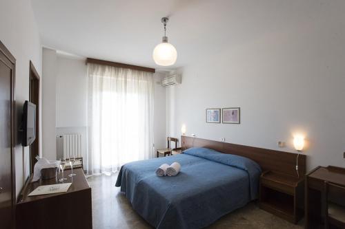ein Schlafzimmer mit einem blauen Bett mit zwei Kissen darauf in der Unterkunft Albergo Rossana in Chianciano Terme