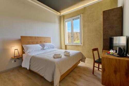 a bedroom with a bed and a television and a desk at La Dama Country Rooms in Monteriggioni