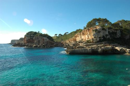 a view of the ocean with rocks in the water at Can Juanito by dracmallorca in Cala Llombards