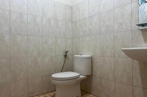 a bathroom with a toilet and a sink at OYO 93877 Atifah Homes in Sungguminasa