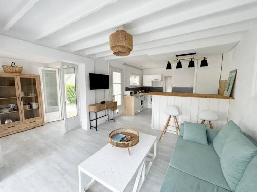 un salon avec un canapé bleu et une cuisine dans l'établissement Charmante maison pour 6 personnes, à La Teste-de-Buch