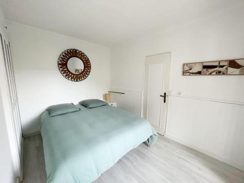 une chambre blanche avec un lit et un miroir dans l'établissement Charmante maison pour 6 personnes, à La Teste-de-Buch