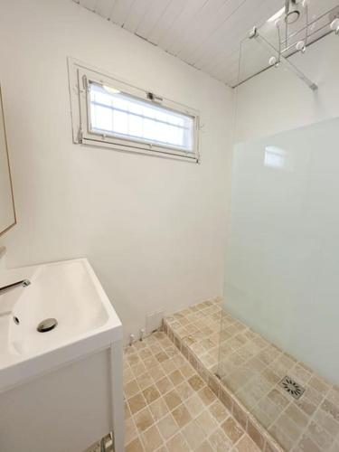 une salle de bain blanche avec un lavabo et une fenêtre dans l'établissement Charmante maison pour 6 personnes, à La Teste-de-Buch