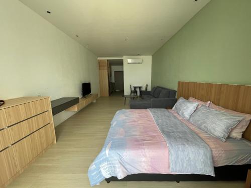 ein Schlafzimmer mit einem großen Bett und einem Sofa in der Unterkunft Freedom Flamingos@Roxy Beach in Lundu