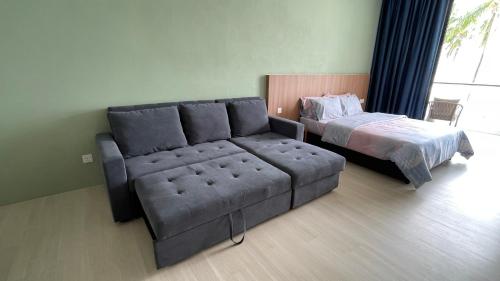 ein Wohnzimmer mit einem Sofa und einem Bett in der Unterkunft Freedom Flamingos@Roxy Beach in Lundu