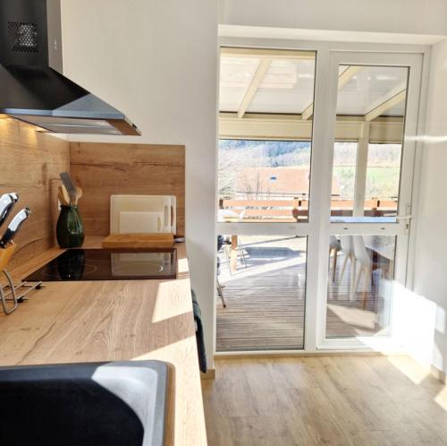 a kitchen with a sliding glass door leading to a patio at La Vision en Vosges in Xamontarupt