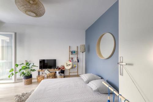une chambre avec un lit avec un mur bleu dans l'établissement C4 Les Jardins d'Orsonville, à Chessy