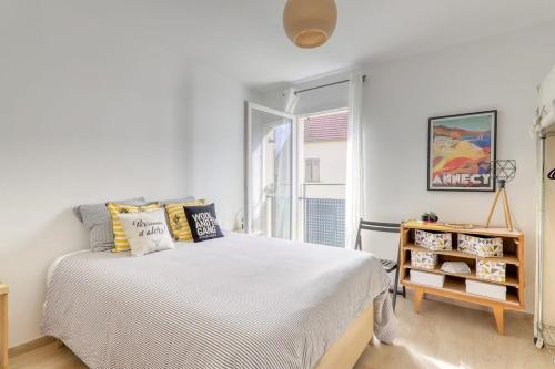 a white bedroom with a bed and a window at C4 Les Jardins d'Orsonville in Chessy