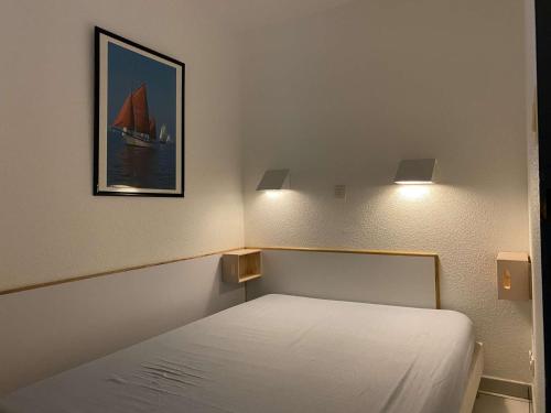 um quarto com uma cama com uma fotografia de um barco em Ref 006 - Appartement 2 pièces à deux pas de la plage et du port, à louer pour les vacances em Arzon