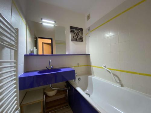 uma casa de banho com um lavatório azul e uma banheira em Ref 006 - Appartement 2 pièces à deux pas de la plage et du port, à louer pour les vacances em Arzon