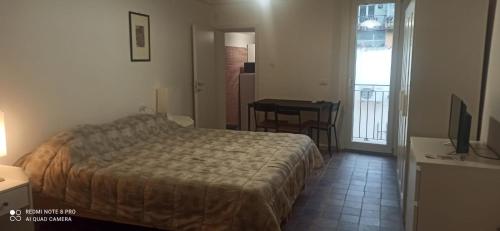 een slaapkamer met een bed, een tafel en een bureau bij BELLA PRIMO PIANO in Forlì