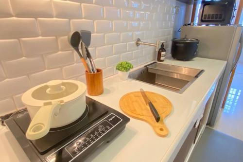 a kitchen counter with a stove with a cutting board at Atia’s Tiny House in General Trias