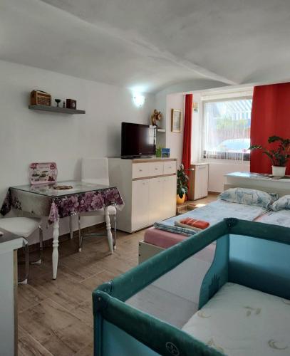 a room with two beds and a table and a kitchen at Apartments Karin in Bled
