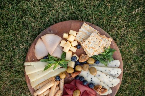 a plate of cheese and crackers and snacks on the grass at MAIA Luxury Beach Hotel & Spa in Guzelcamlı