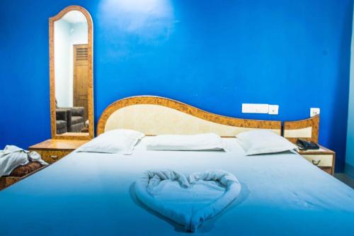 ein blaues Bett mit einem herzförmigen Kissen darauf in der Unterkunft Hotel Raj in Puri