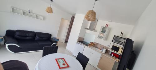 un salon avec un canapé et une table dans l'établissement Appartement neuf 39m2 avec balcon à 250m de la plage, à Saint-Vincent-sur-Jard