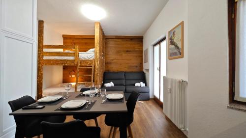 a dining room with a table and chairs and a bunk bed at Hostdomus - Royal Oak in Sestriere