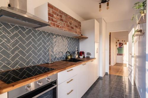 une cuisine avec des placards blancs et un mur en briques dans l'établissement Disney Mario Nintendo, à Montévrain