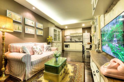 a living room with a couch and a flat screen tv at The Title Boutique Phuket in Rawai Beach