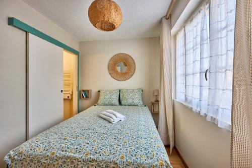 ein Schlafzimmer mit einem Bett mit zwei Handtüchern darauf in der Unterkunft Les Violettes - Appt à 200 m de la plage in Saint-Aubin-sur-Mer