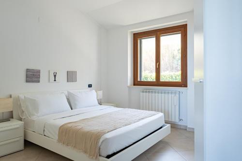 een witte slaapkamer met een bed en een raam bij Cintioni a mare 2E - YourPlace Abruzzo in Marina di San Vito