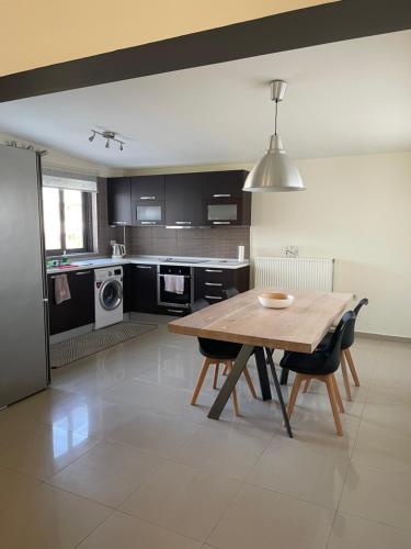 Una cocina con una mesa de madera y algunas sillas. en Calm Haven 2024, en Ialisos