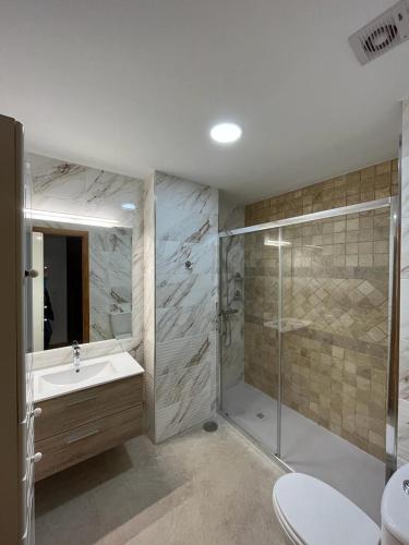 a bathroom with a shower and a sink and a toilet at Apartamento La Atalaya C-162 in Conil de la Frontera