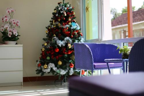 a christmas tree in the corner of a room at Takanta Place in Udon Thani
