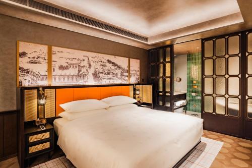 a bedroom with a large white bed in it at Hotel Central Macau in Macau