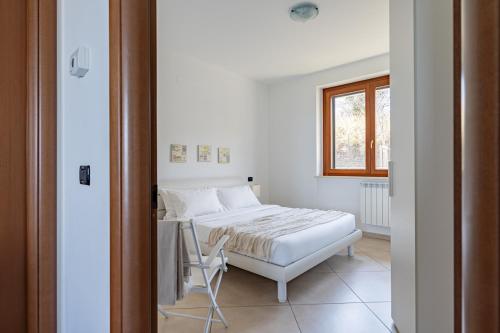 1 dormitorio con 1 cama, 1 silla y 1 ventana en Cintioni a mare C 9 - YourPlace Abruzzo, en Marina di San Vito