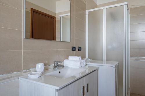 Baño blanco con lavabo y espejo en Cintioni a mare C 9 - YourPlace Abruzzo, en Marina di San Vito