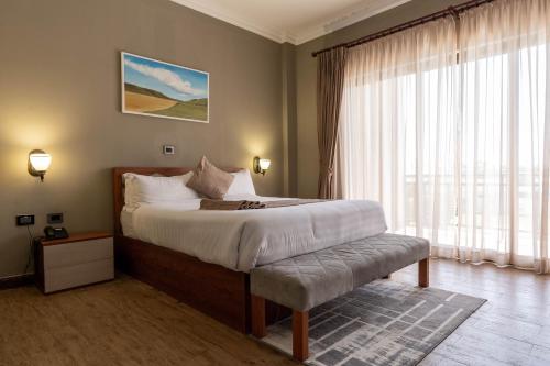 una camera con un grande letto e una grande finestra di Haile Hotel Wolaita a Sodo