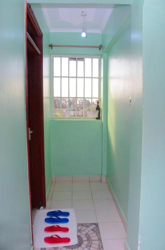a room with green walls and a door and a window at Amani Homes in Eldoret