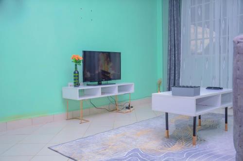 a living room with a tv and a blue wall at Amani Homes in Eldoret